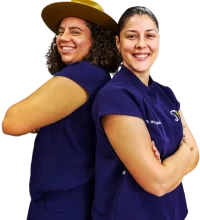 En esta foto se encuentran la Doctora Raysha y la Doctora Amanda, espalda contra espalda, ambas con su uniforme médico de trabajo